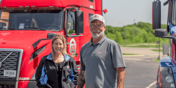 ATS driver with driver manager standing in front ATS fleet, OTR driver pay