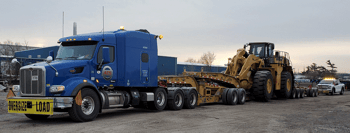 11-axle removable gooseneck (RGN) trailer parked in front of pilot car escort