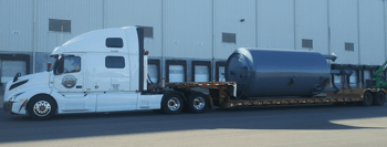 Double drop RGN parked outside warehouse facility