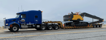 Three-axle removable gooseneck (RGN) pulling an excavator