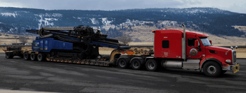 8-axle removable gooseneck (RGN) trailer parked near mountains